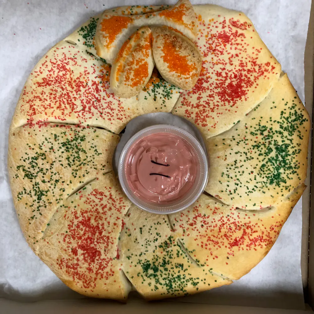 A ring of Woodstock's breadsticks around a cup of dipping sauce